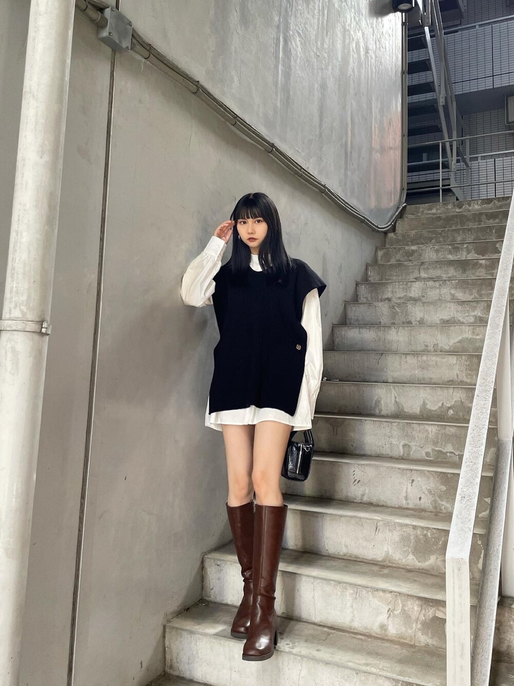 ブラック系のワンピース、ブラウン系のブーツを着用したレディースの夏コーディネートの1枚目の写真