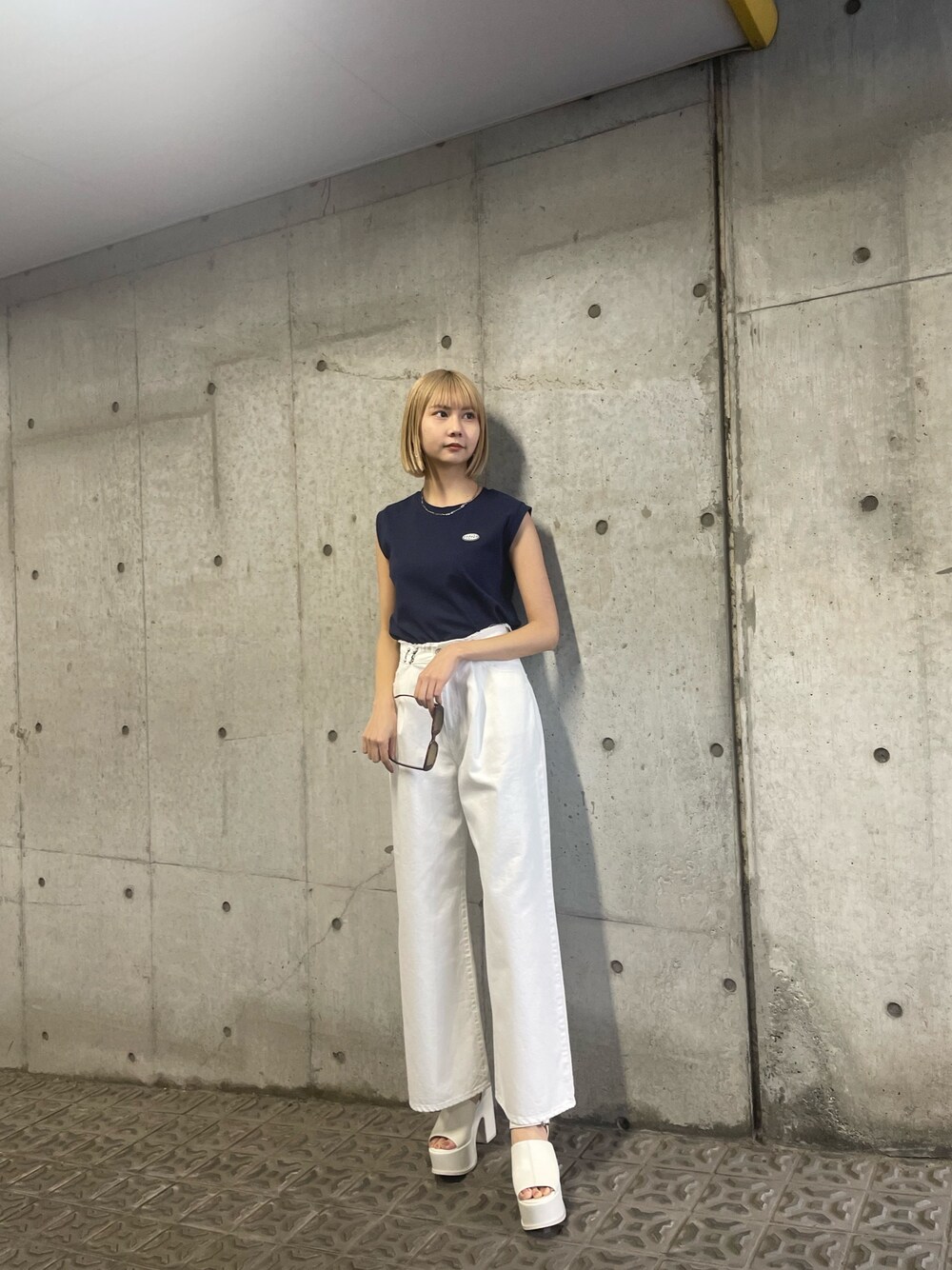 ブルー系のタンクトップ、ホワイト系のデニムパンツを着用したレディースの冬コーディネートの1枚目の写真