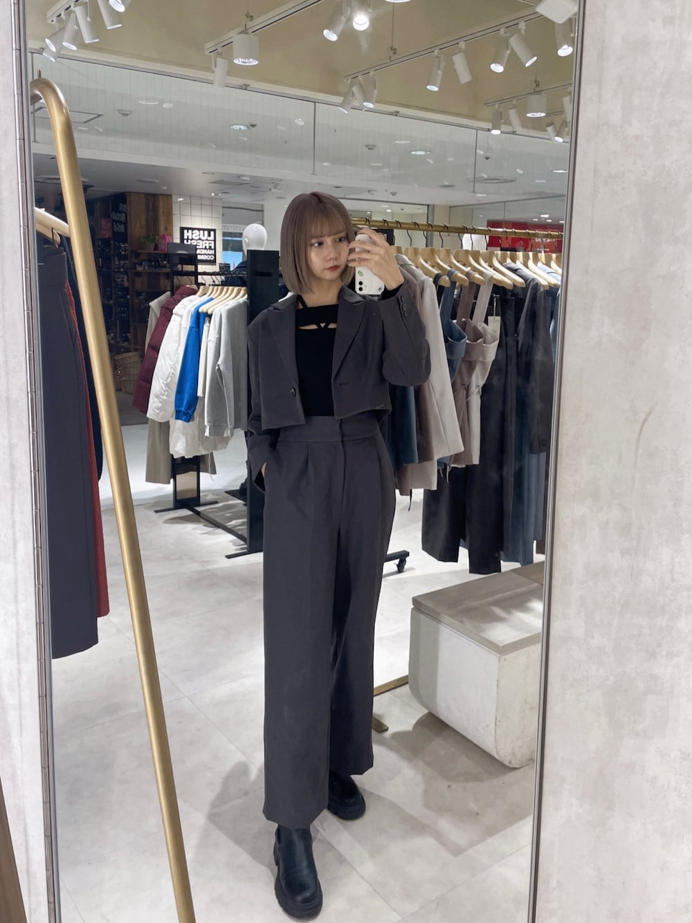 グレー系のテーラードジャケット、グレー系のその他パンツ、ブラック系のニット/セーターを着用したレディースの春コーディネートの1枚目の写真