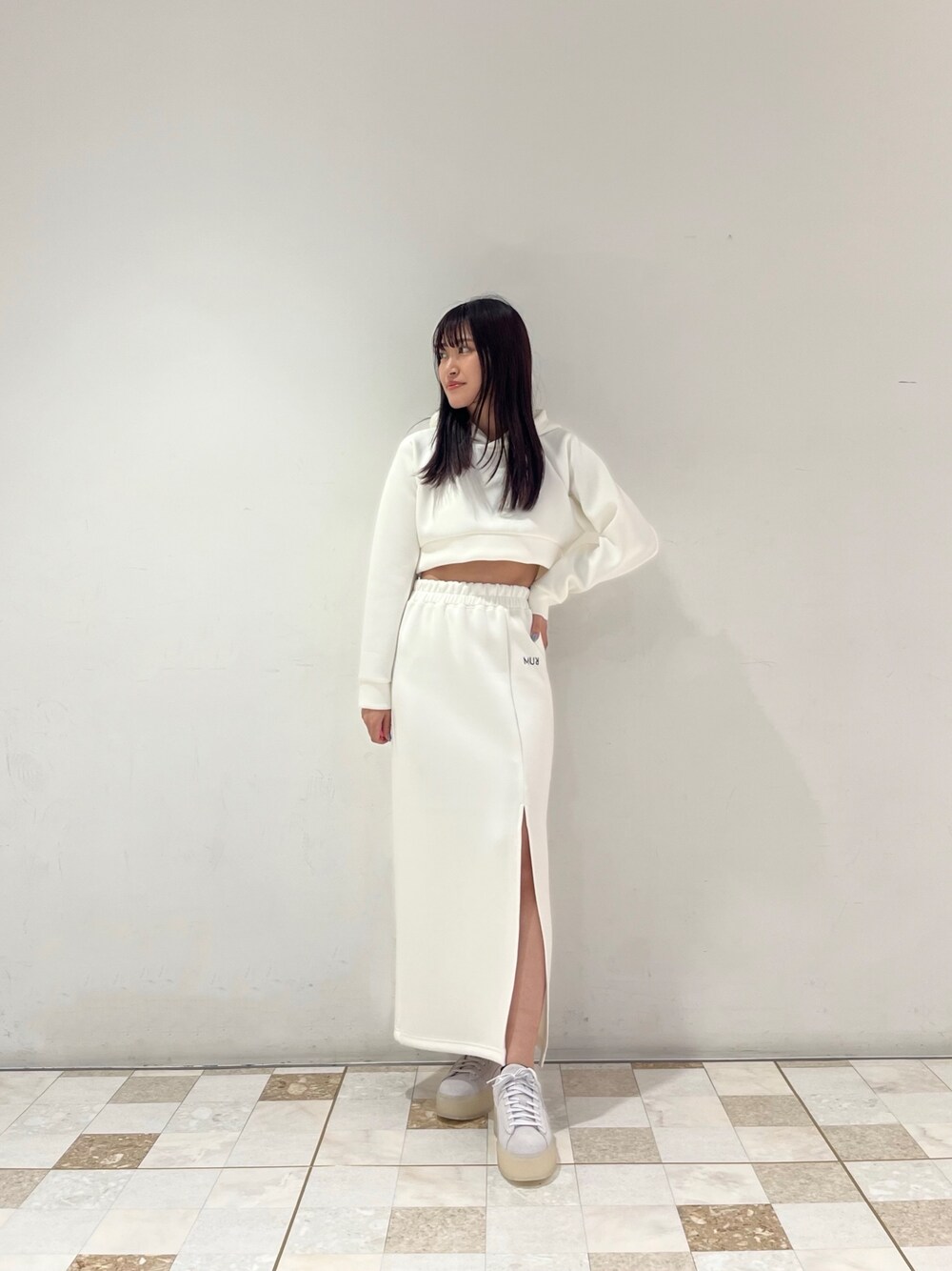 ホワイト系のTシャツ/カットソー、ホワイト系のスカート、グレー系のスニーカーを着用したレディースの春コーディネートの1枚目の写真