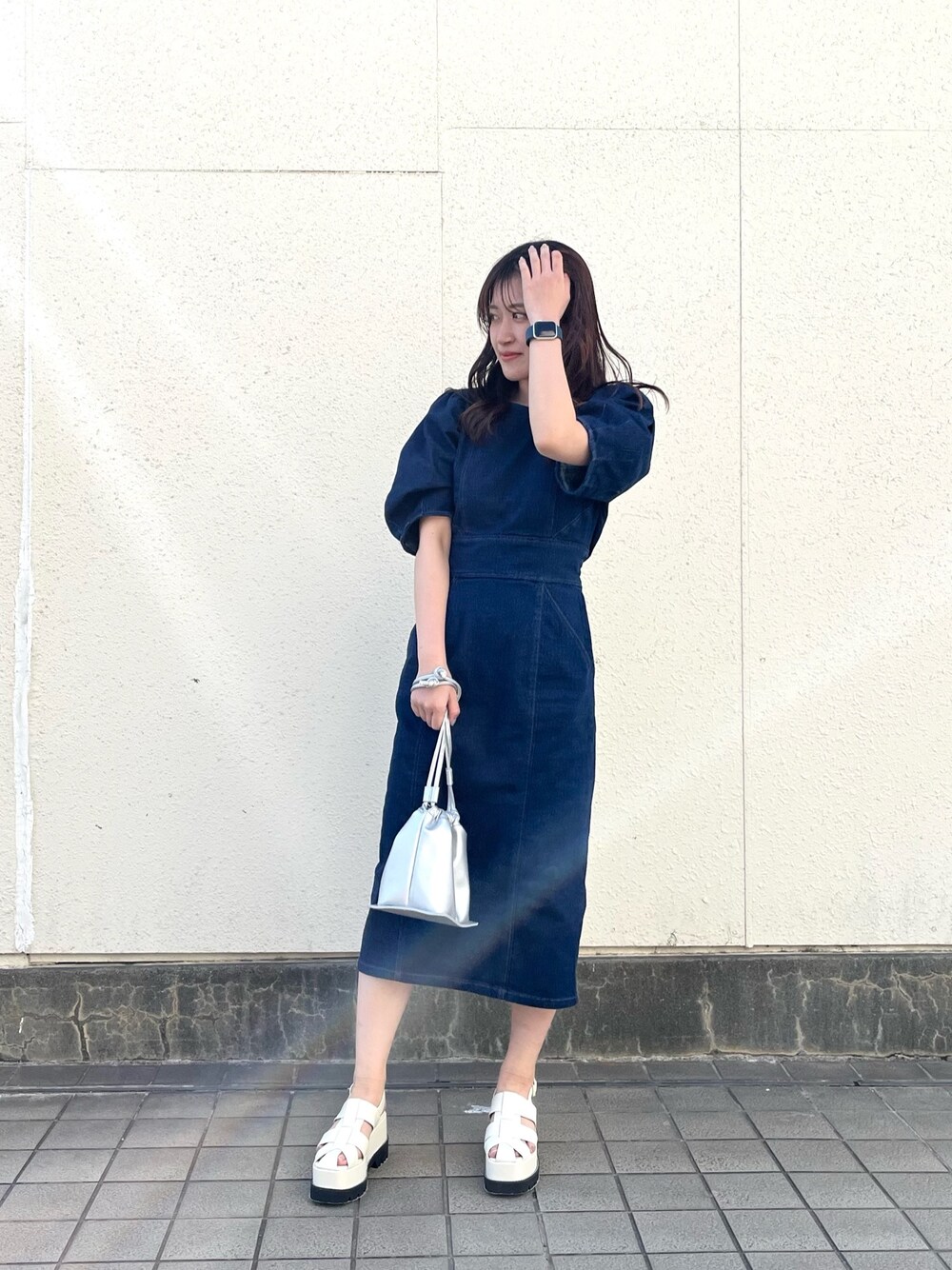 ブルー系のワンピース、シルバー系のハンドバッグ、ホワイト系のサンダルを着用したレディースの春コーディネートの1枚目の写真