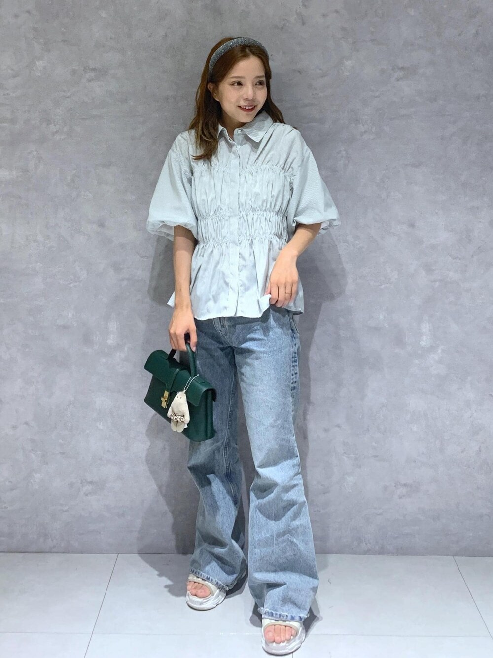 グリーン系のショルダーバッグ、ブルー系のデニムパンツ、グリーン系のシャツ/ブラウスを着用したレディースの夏コーディネートの1枚目の写真