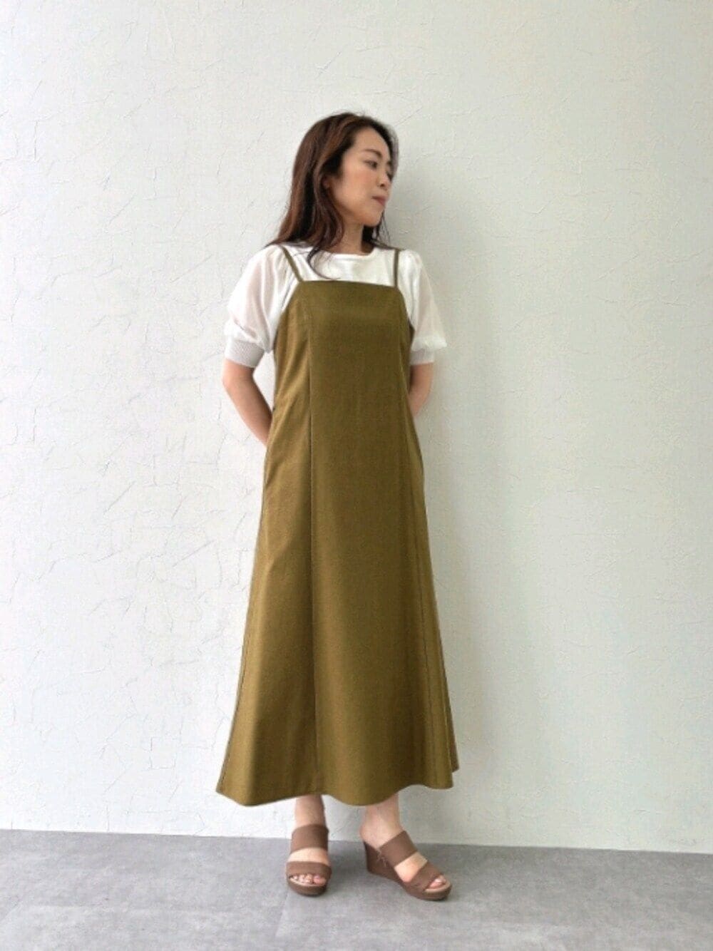 グリーン系のワンピース、ホワイト系のニット/セーターを着用したレディースの夏コーディネートの1枚目の写真