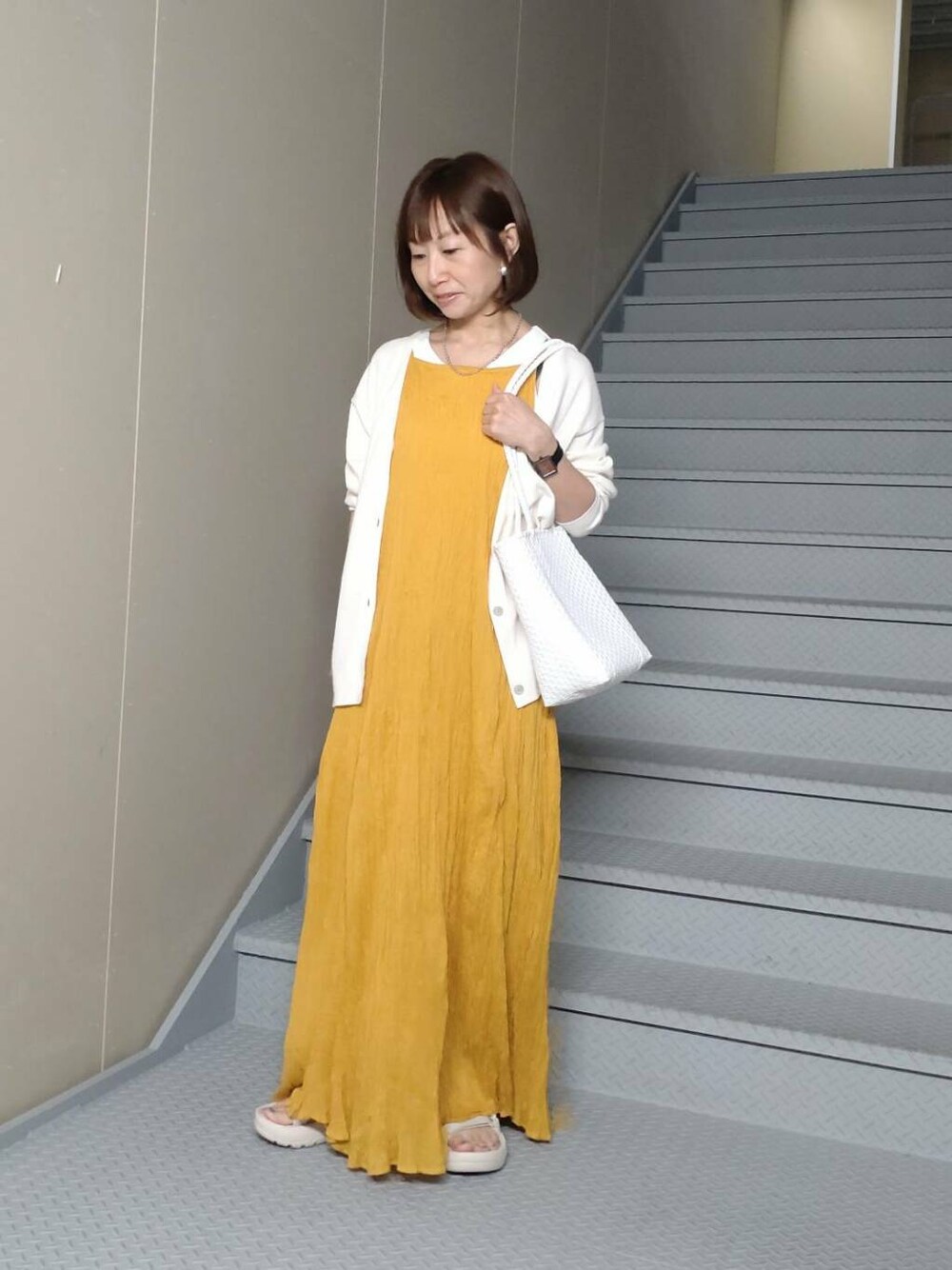 ホワイト系のタンクトップ、ホワイト系のカーディガン/ボレロ、ホワイト系のトートバッグを着用したレディースの春コーディネートの1枚目の写真