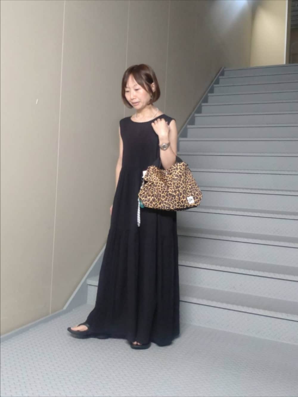 ブラック系のワンピース、その他のショルダーバッグ、グリーン系のキーホルダーを着用したレディースの夏コーディネートの1枚目の写真
