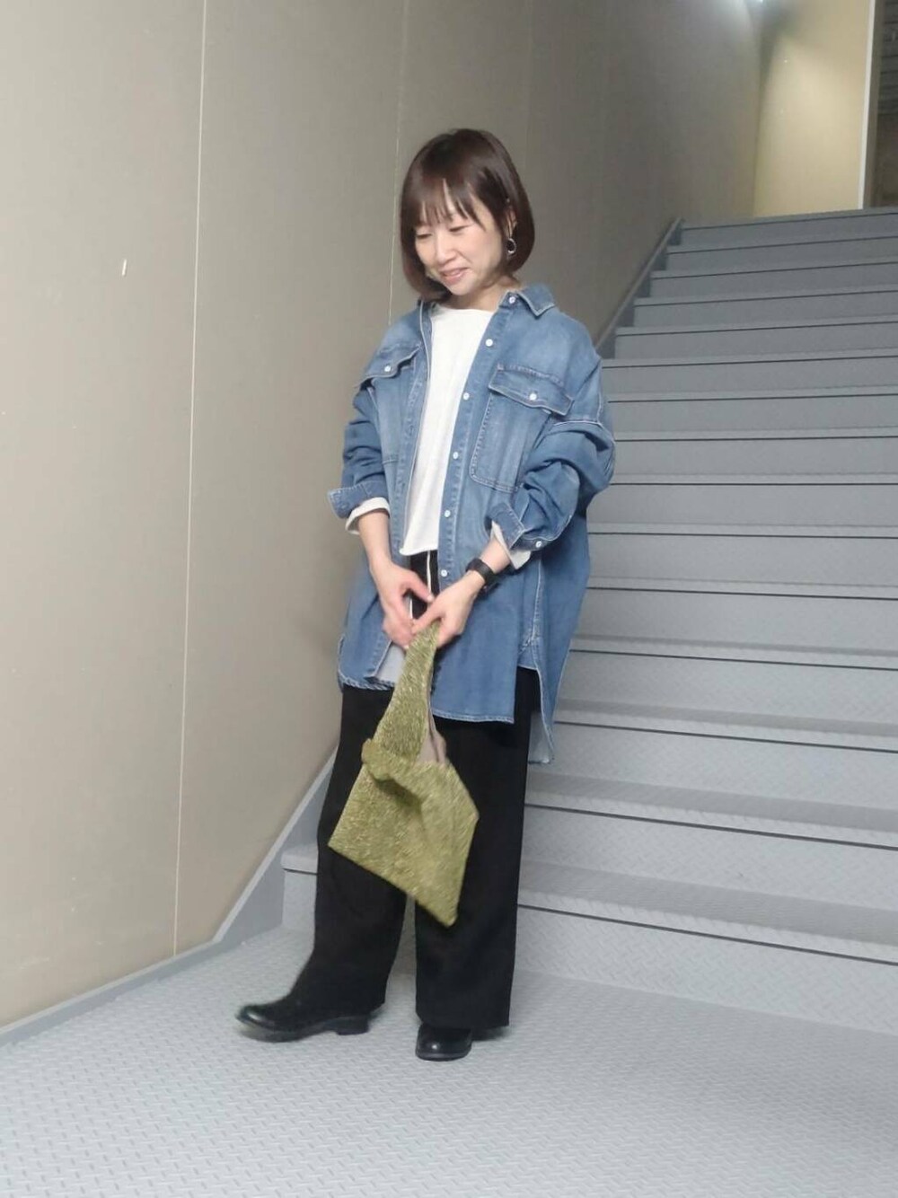 ゴールド系のトートバッグ、ブルー系のシャツ/ブラウス、ベージュ系のスウェットを着用したレディースの冬コーディネートの1枚目の写真
