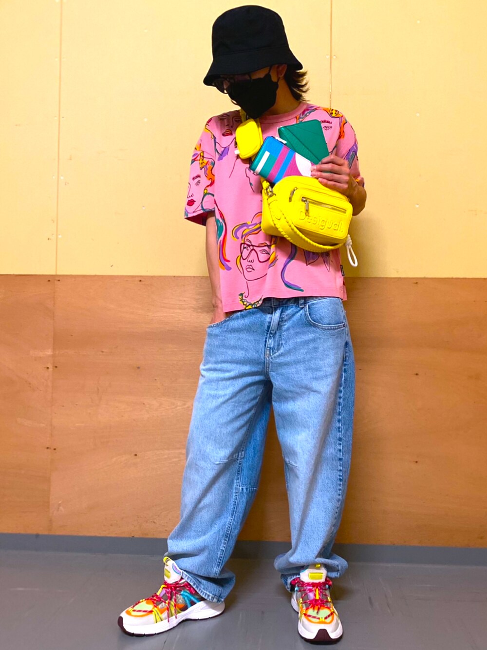 ブルー系のデニムパンツ、イエロー系のボディバッグ/ウエストポーチ、グリーン系の財布を着用したレディースの春コーディネートの1枚目の写真