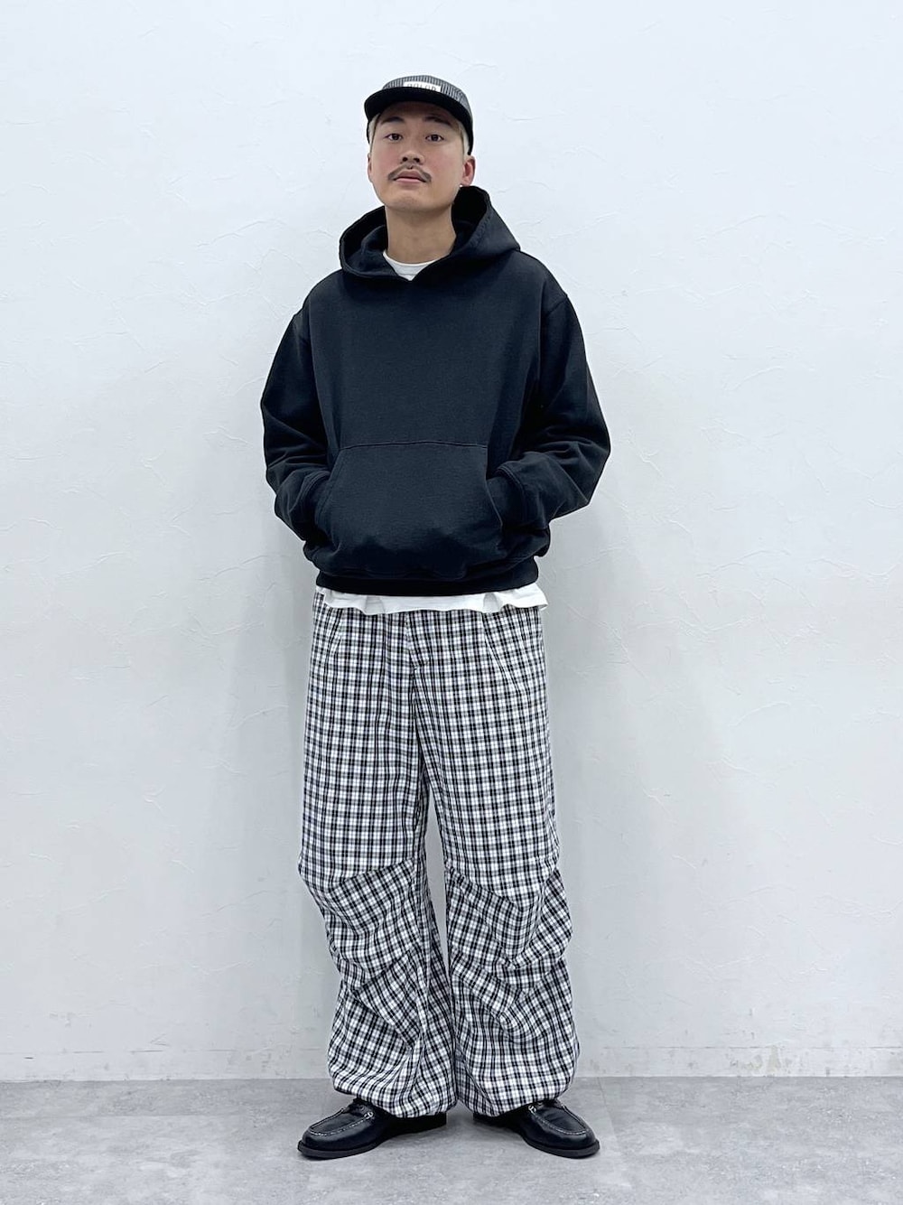 ホワイト系のTシャツ/カットソー、ブラック系のパーカー、ブラック系のモカシン/デッキシューズを着用したメンズの冬コーディネートの1枚目の写真