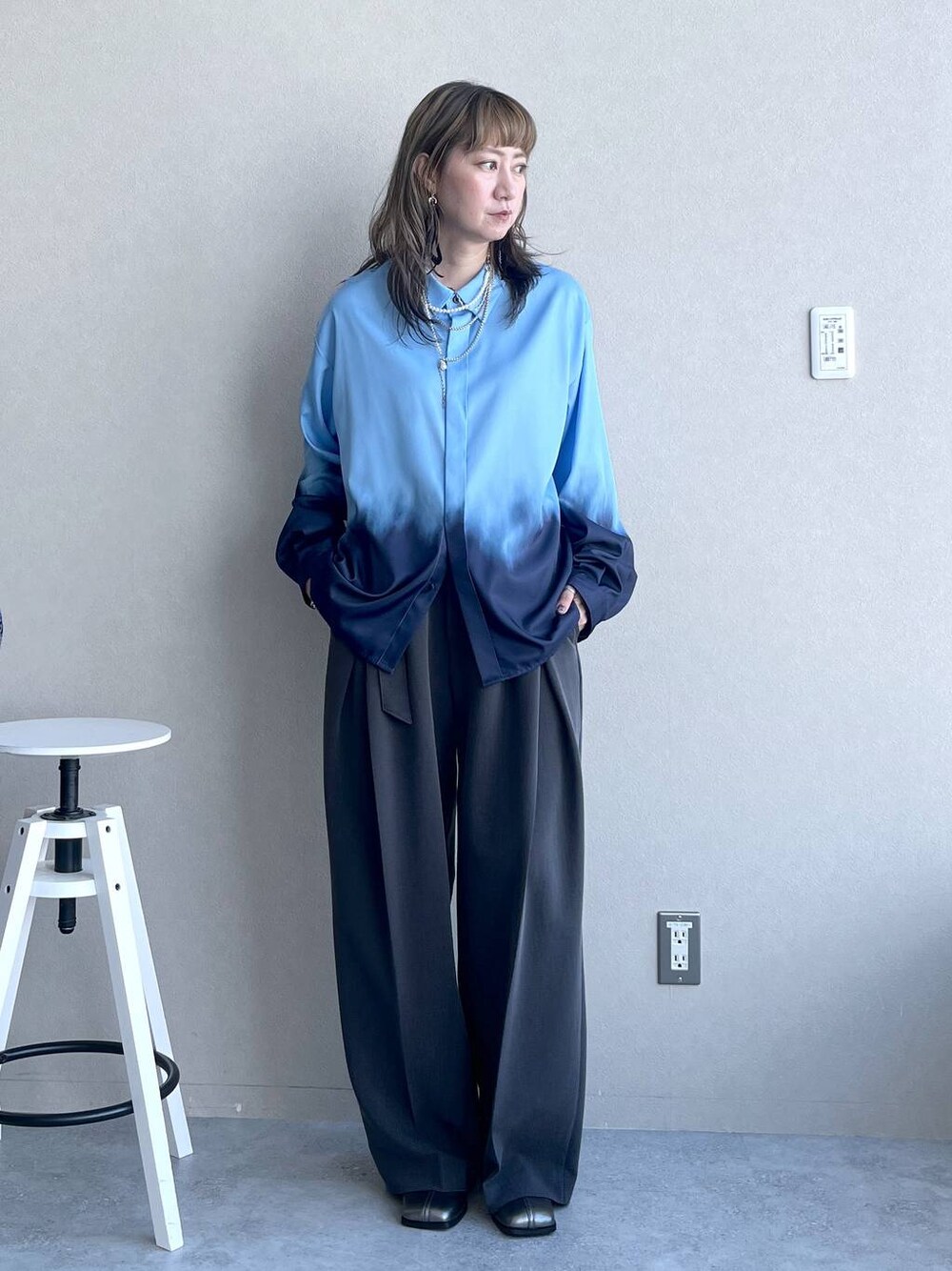 シルバー系のブーツ、ブラック系のピアス（両耳用）、シルバー系のネックレスを着用したレディースの秋コーディネートの1枚目の写真