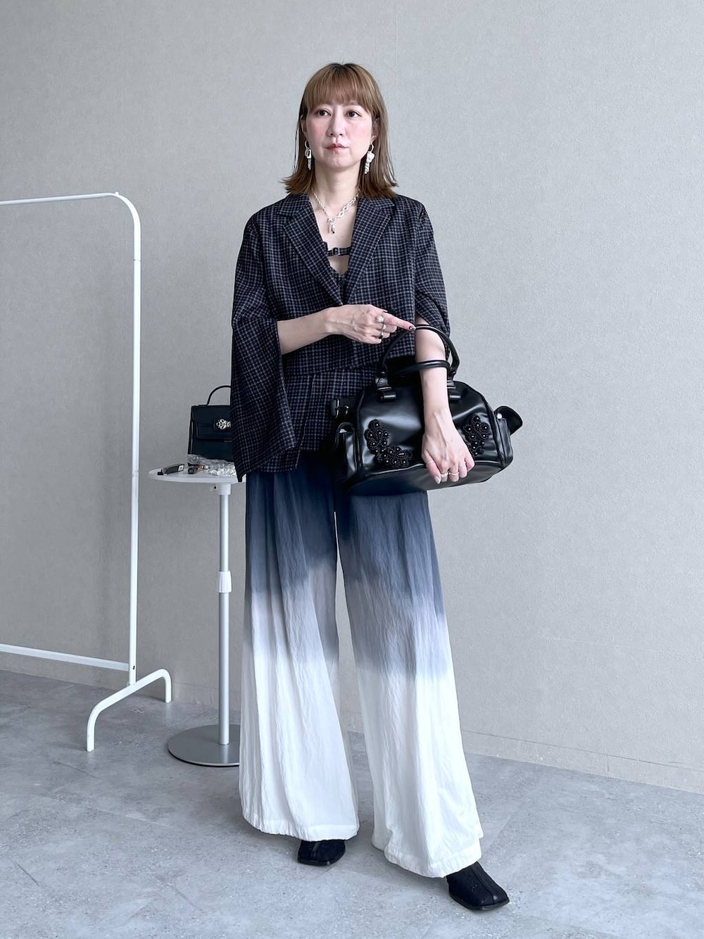 ブラック系のブーツ、ブラック系のボストンバッグ、ブラック系のその他パンツを着用したレディースの冬コーディネートの1枚目の写真