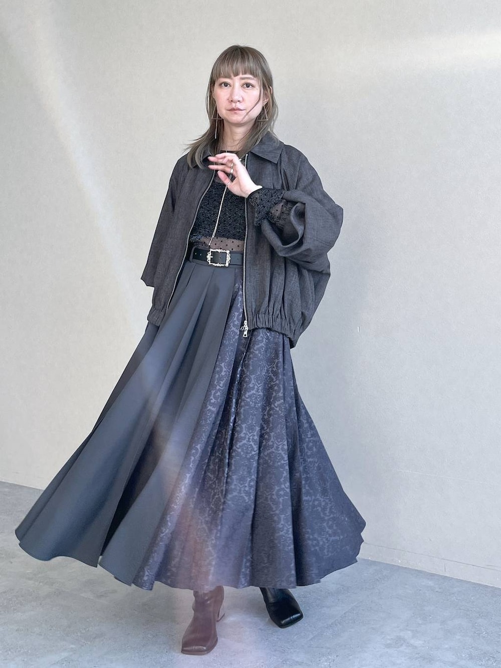 ブラック系のTシャツ/カットソー、ブラック系のボストンバッグ、ブラック系のブーツを着用したレディースの秋コーディネートの1枚目の写真