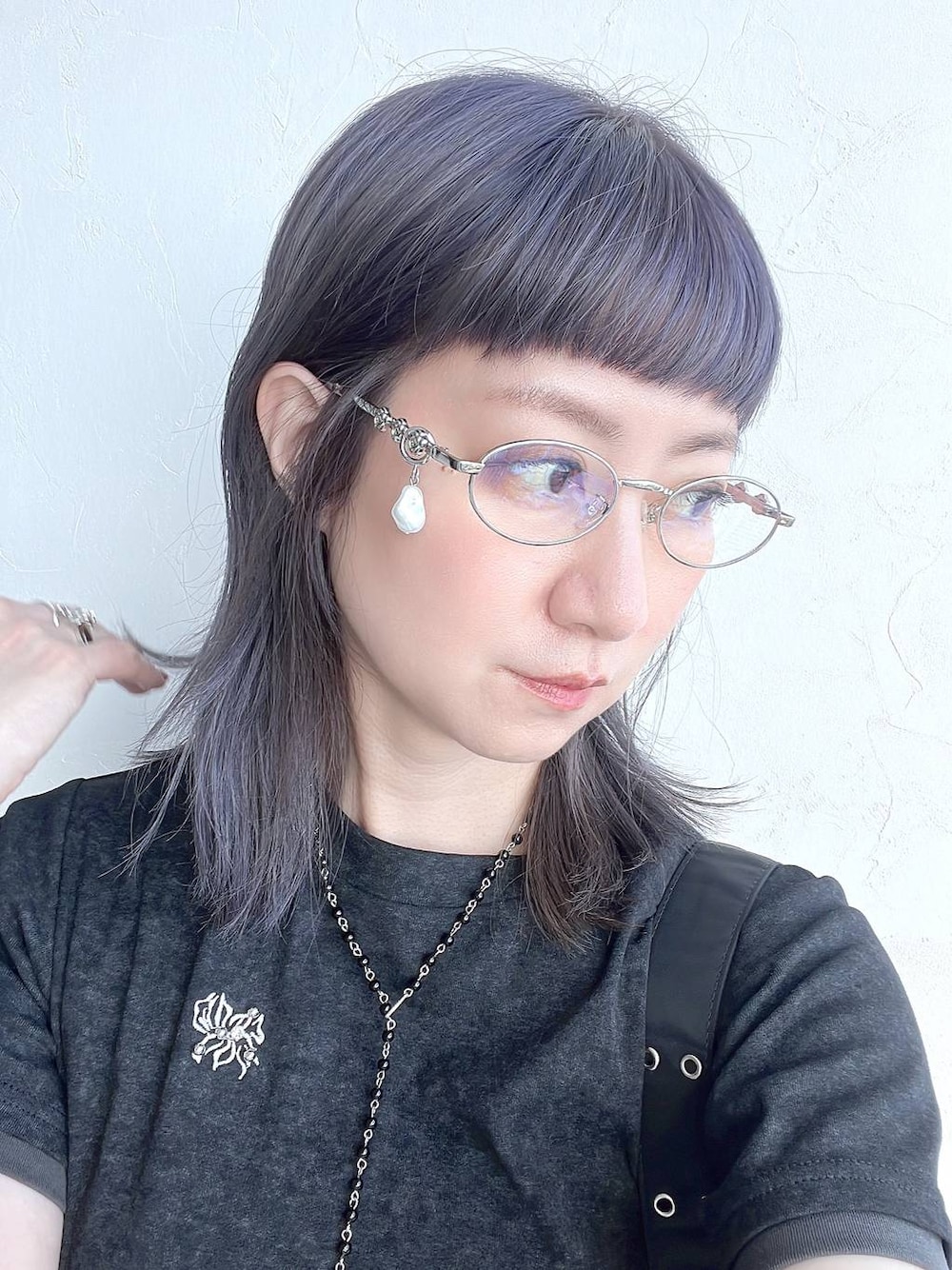 ブラック系のTシャツ/カットソー、ブラック系のネックレス、シルバー系のメガネを着用したレディースの春コーディネートの1枚目の写真