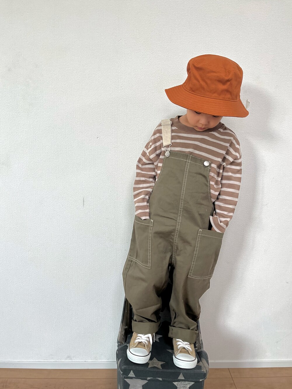 ブラウン系のTシャツ/カットソー、グリーン系のサロペット/オーバーオール、ベージュ系のスニーカーを着用したキッズの秋コーディネートの1枚目の写真