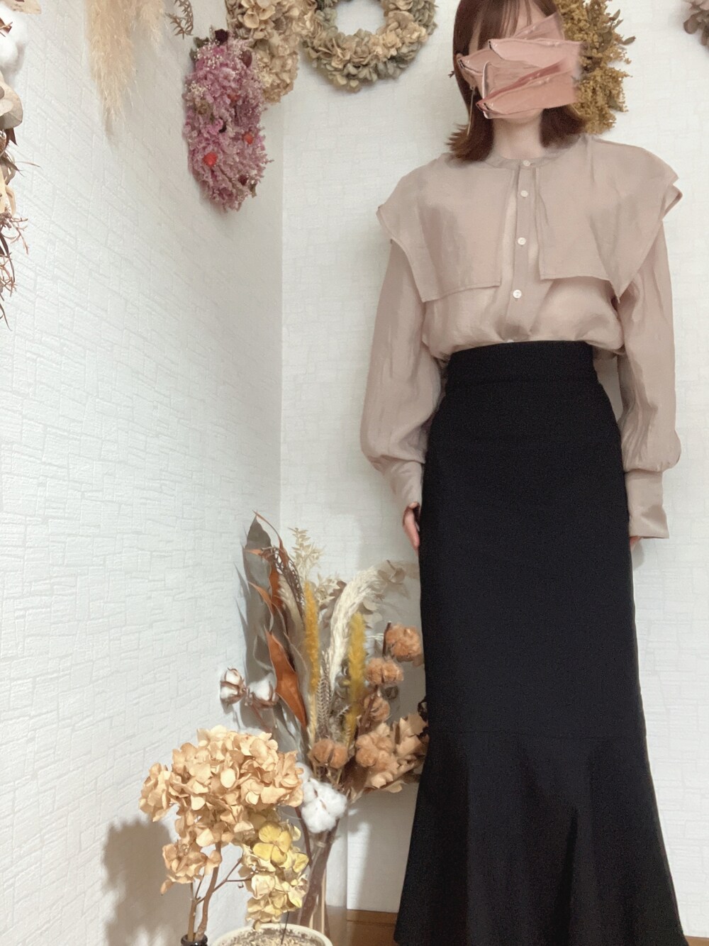 ベージュ系のシャツ/ブラウス、ブラック系のスカート、ベージュ系のピアス(両耳用)を着用したレディースの秋コーディネートの1枚目の写真