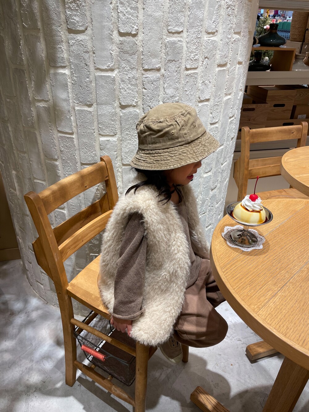 ホワイト系のベスト、ブラウン系のハットを着用したキッズの冬コーディネートの1枚目の写真