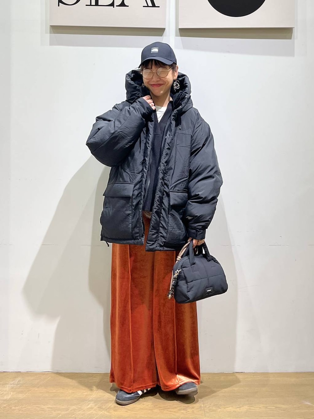 ブラック系のダウンジャケット/コート、レッド系のその他パンツ、ブラック系のボストンバッグを着用したレディースの冬コーディネートの1枚目の写真