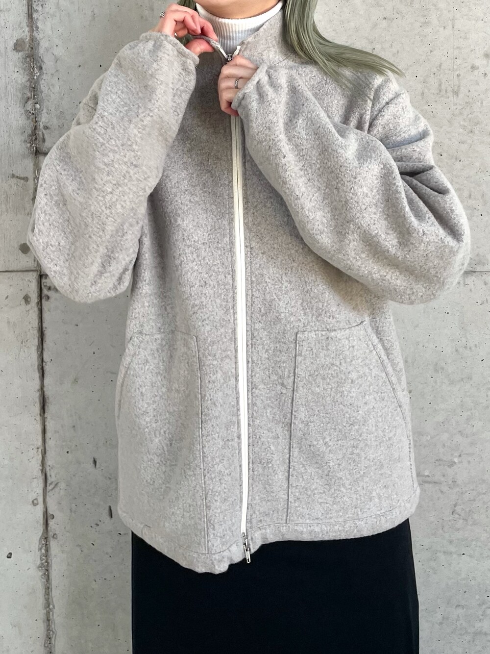 グレー系のブルゾン、ブラウン系のニット/セーター、ブラック系のワンピースを着用したレディースの冬コーディネートの3枚目の写真