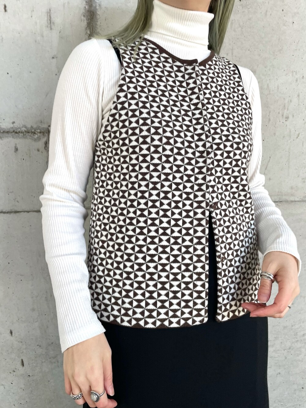 グレー系のブルゾン、ブラウン系のニット/セーター、ブラック系のワンピースを着用したレディースの冬コーディネートの4枚目の写真