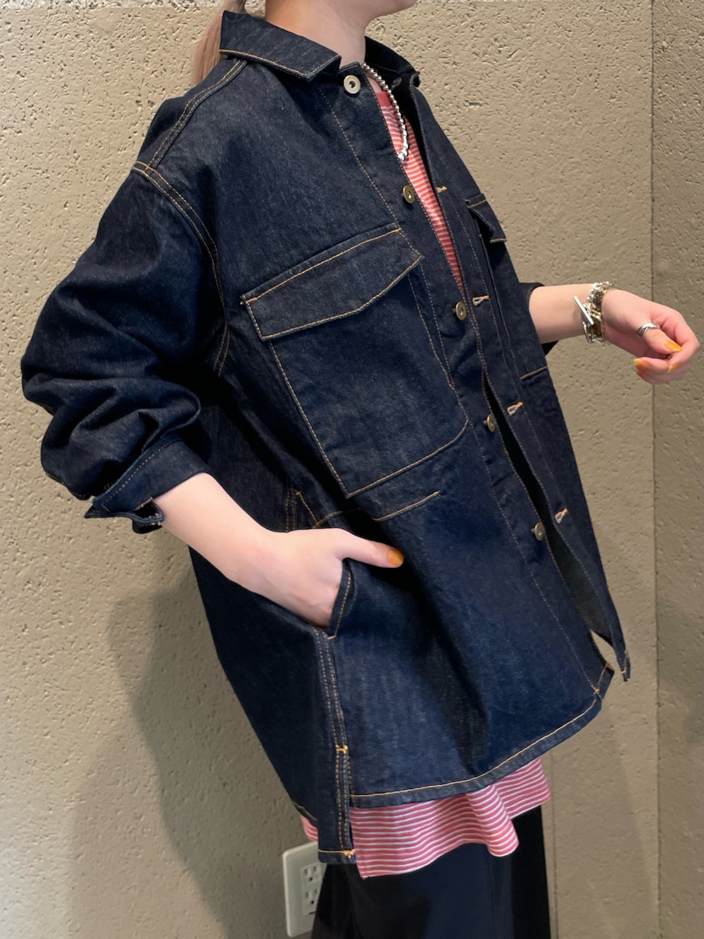 ブルー系のデニムジャケット、レッド系のTシャツ/カットソー、ブラック系のスカートを着用したレディースの春コーディネートの2枚目の写真