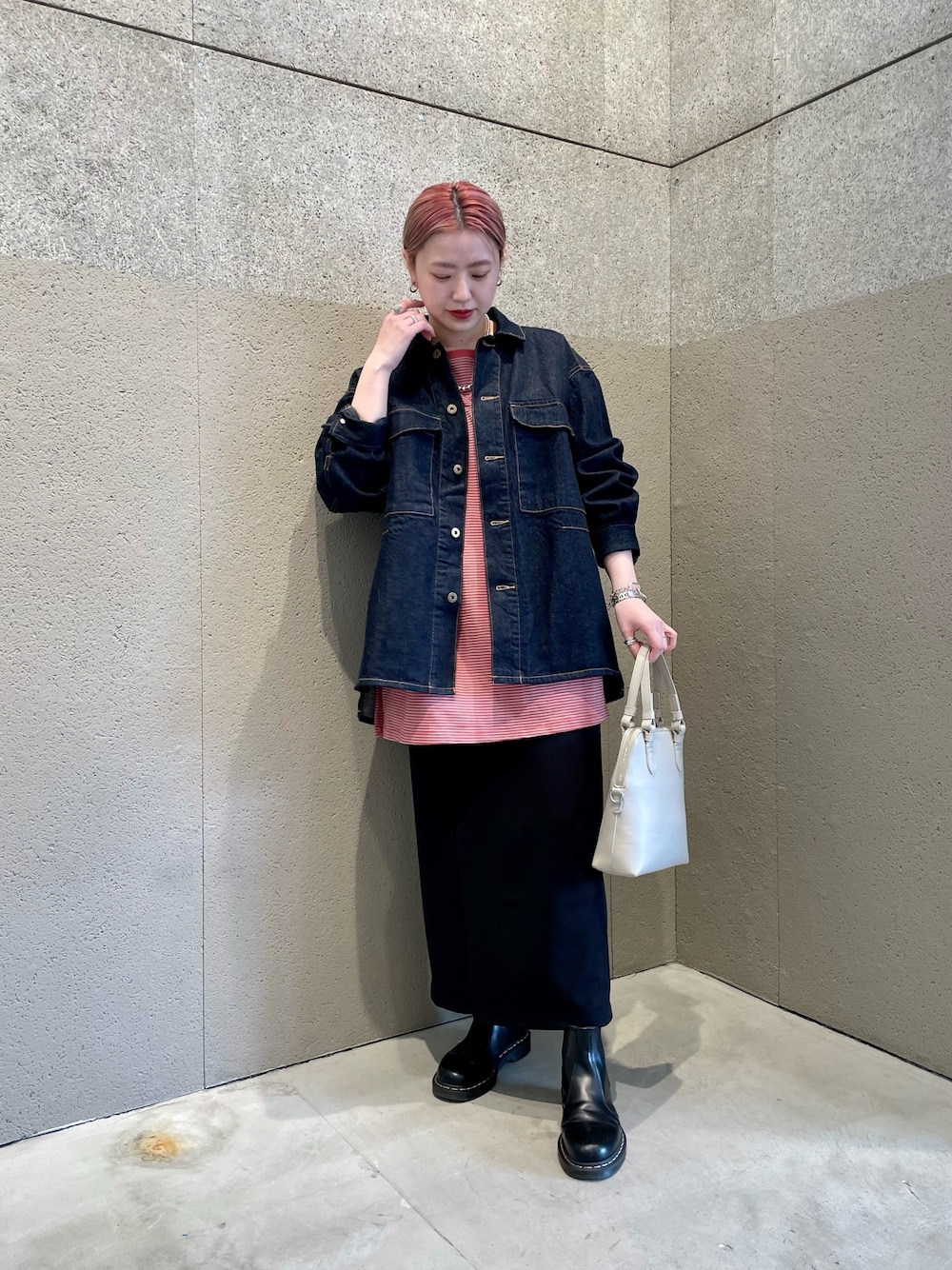 ブルー系のデニムジャケット、レッド系のTシャツ/カットソー、ブラック系のスカートを着用したレディースの春コーディネートの1枚目の写真