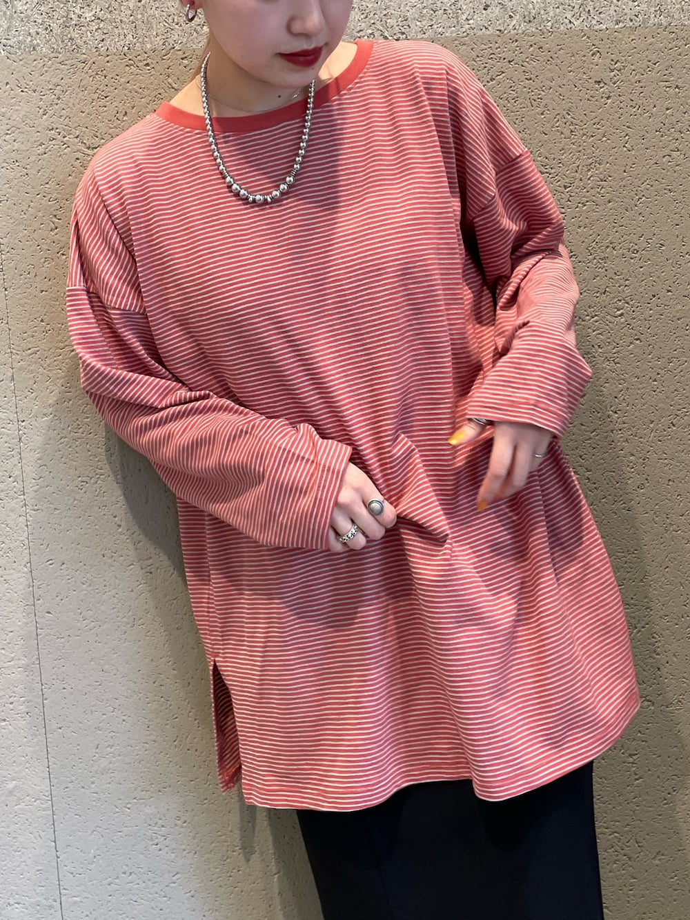 ブルー系のデニムジャケット、レッド系のTシャツ/カットソー、ブラック系のスカートを着用したレディースの春コーディネートの4枚目の写真