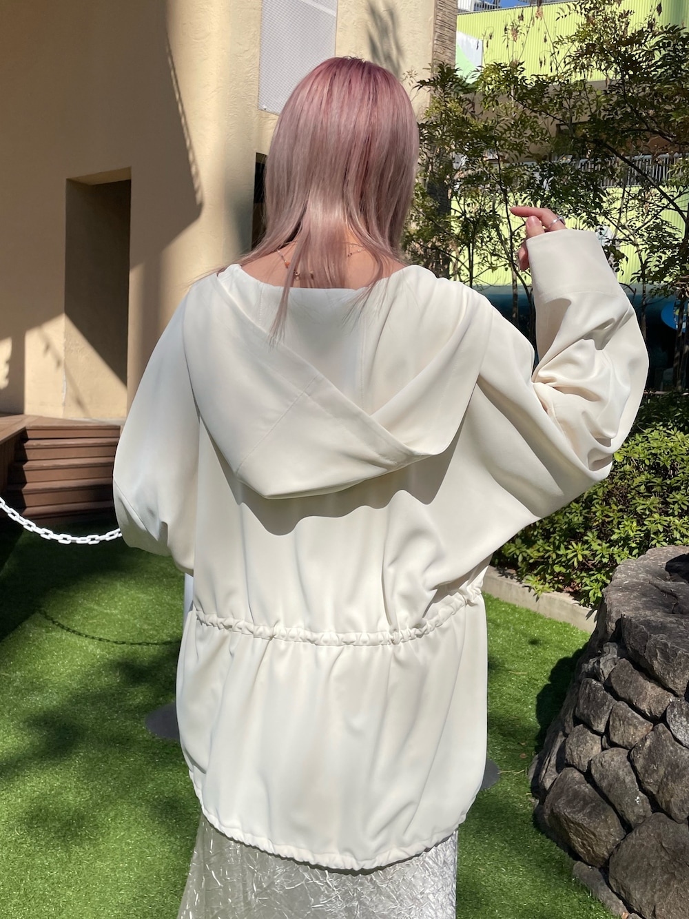ホワイト系のマウンテンパーカー、ホワイト系のTシャツ/カットソー、ベージュ系のスカートを着用したレディースの春コーディネートの4枚目の写真