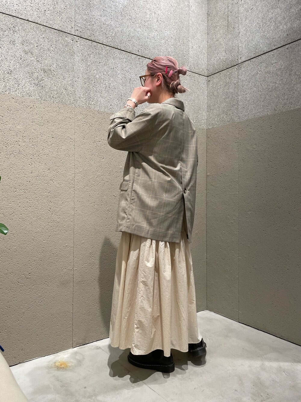 ベージュ系のテーラードジャケット、ホワイト系のスカート、ブラウン系のメガネを着用したレディースの春コーディネートの2枚目の写真