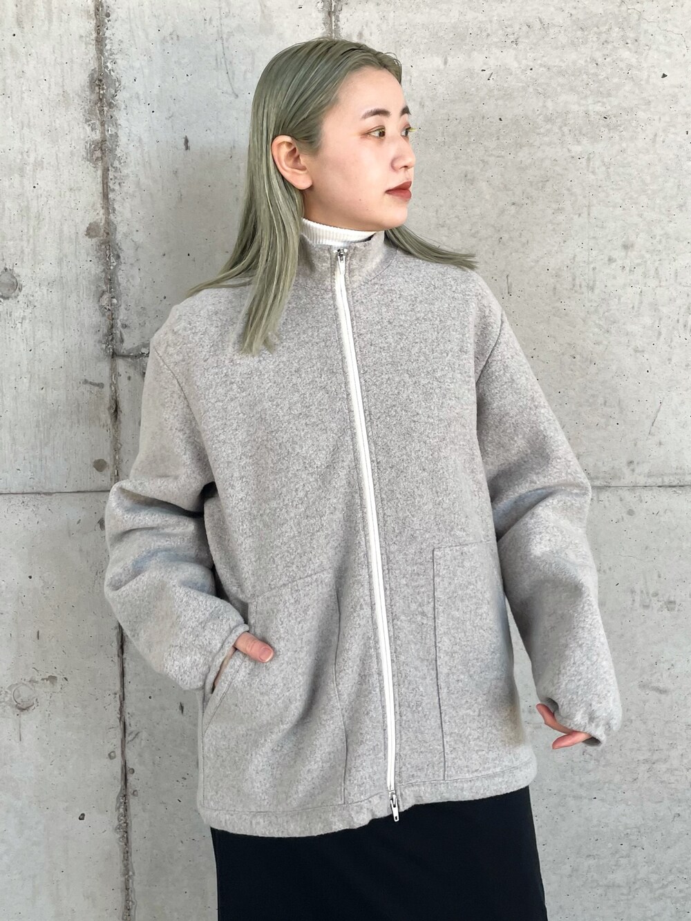 グレー系のブルゾン、ブラウン系のニット/セーター、ブラック系のワンピースを着用したレディースの冬コーディネートの2枚目の写真