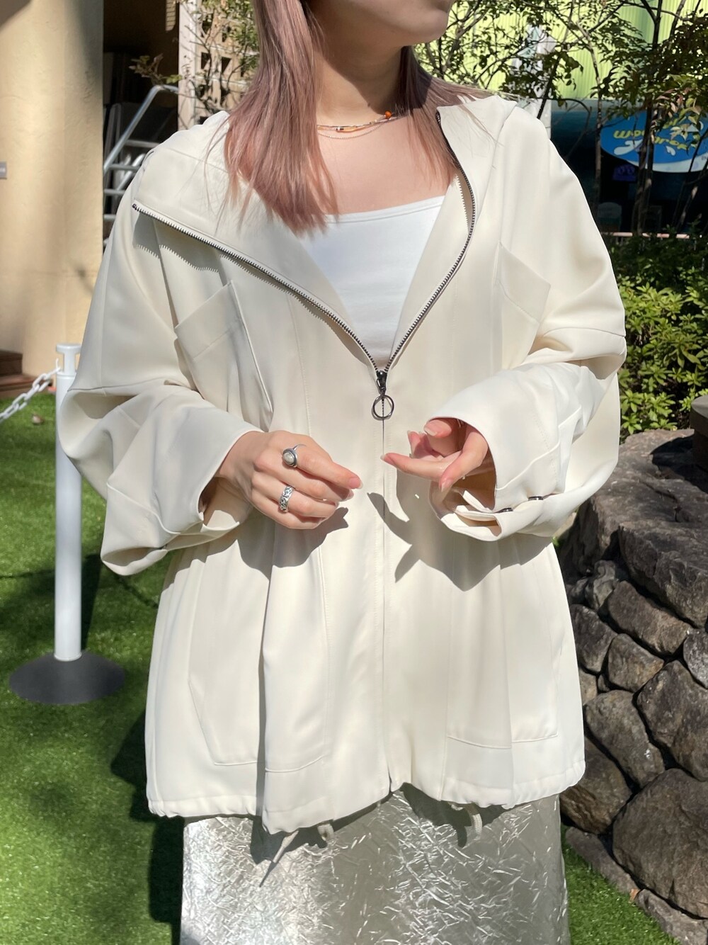 ホワイト系のマウンテンパーカー、ホワイト系のTシャツ/カットソー、ベージュ系のスカートを着用したレディースの春コーディネートの3枚目の写真