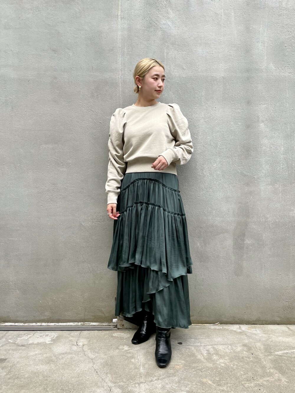 グリーン系のスカート、ベージュ系のスウェットを着用したレディースの秋コーディネートの1枚目の写真
