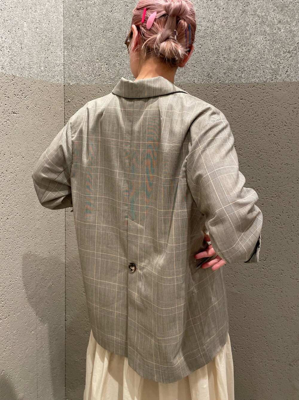 ベージュ系のテーラードジャケット、ホワイト系のスカート、ブラウン系のメガネを着用したレディースの春コーディネートの4枚目の写真