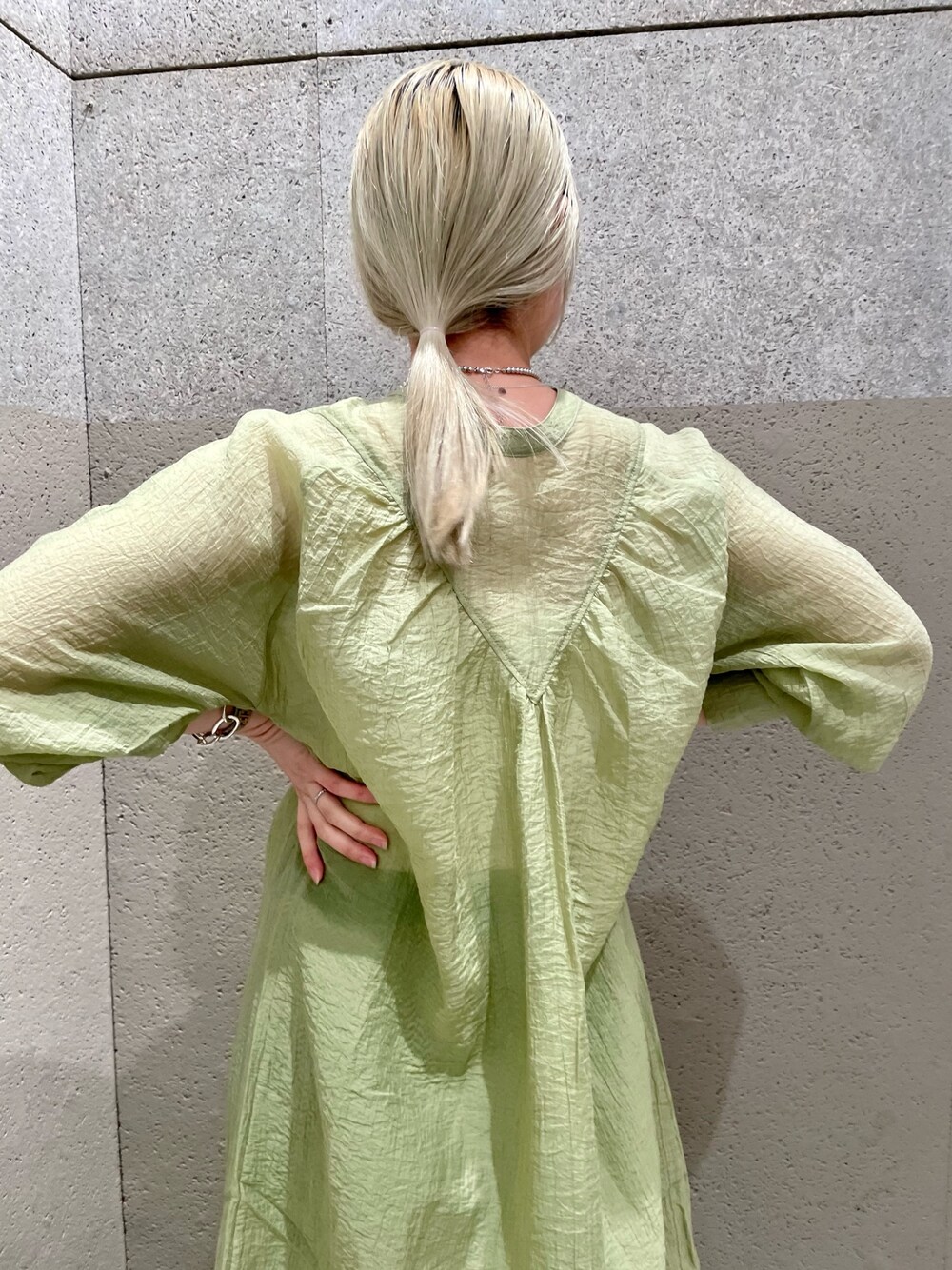 グリーン系のワンピース、イエロー系のトートバッグ、グリーン系のその他パンツを着用したレディースの春コーディネートの4枚目の写真