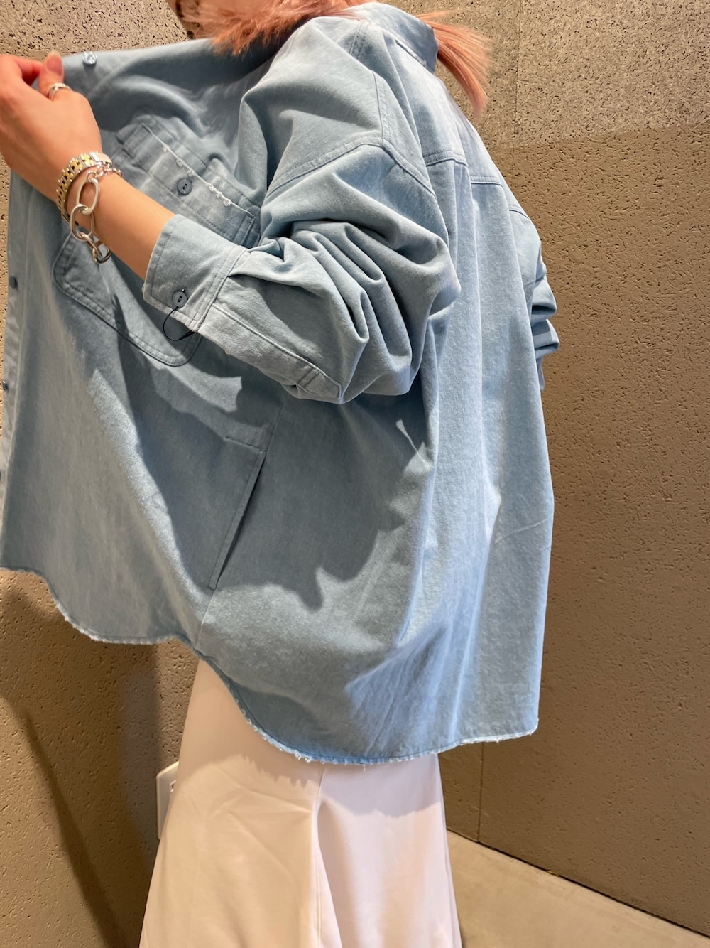 ブルー系のブルゾン、グレー系のTシャツ/カットソー、ホワイト系のスカートを着用したレディースの春コーディネートの3枚目の写真