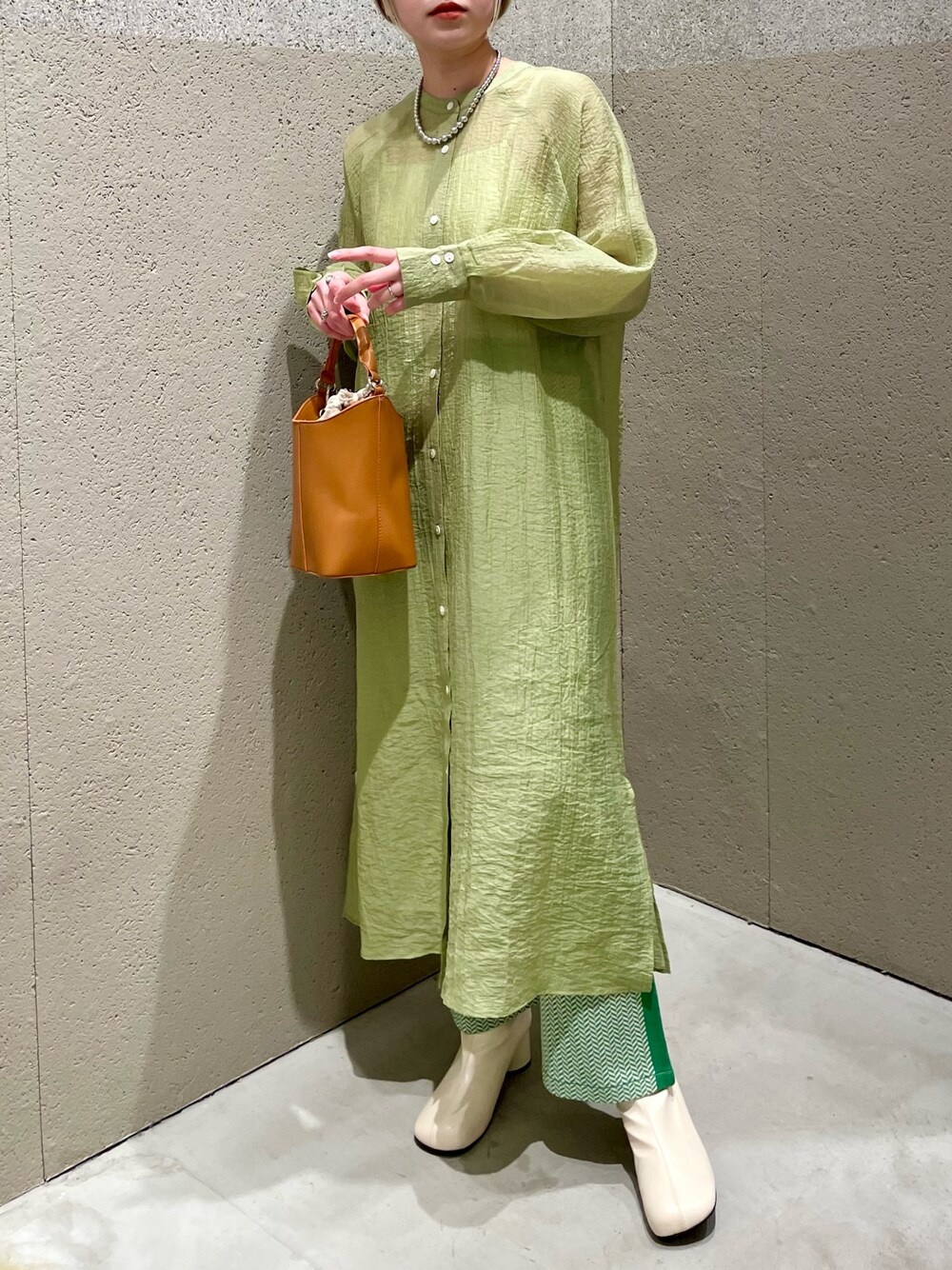 グリーン系のワンピース、イエロー系のトートバッグ、グリーン系のその他パンツを着用したレディースの春コーディネートの2枚目の写真