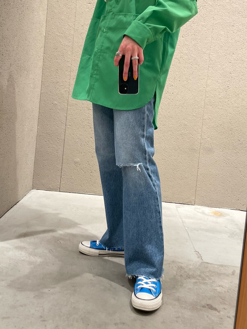 グリーン系のシャツ/ブラウス、ブルー系のデニムパンツ、ブルー系のスニーカーを着用したレディースの春コーディネートの4枚目の写真