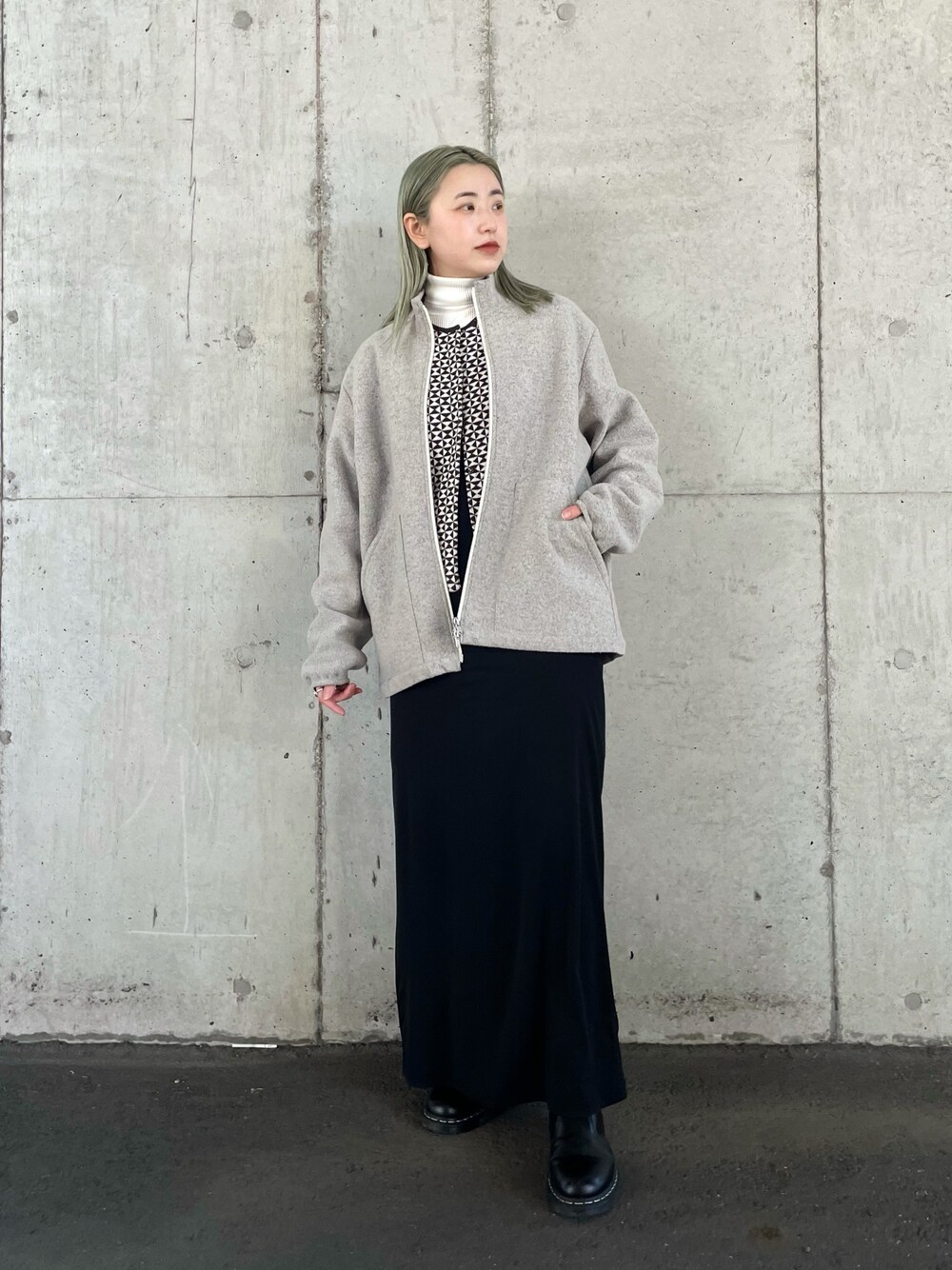 グレー系のブルゾン、ブラウン系のニット/セーター、ブラック系のワンピースを着用したレディースの冬コーディネートの1枚目の写真