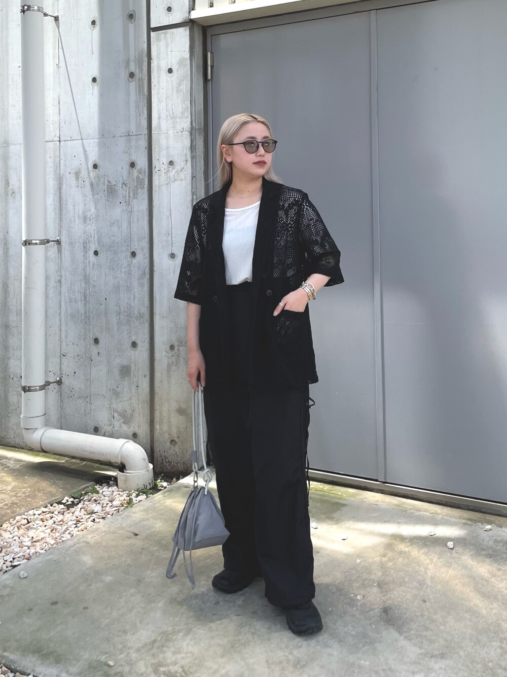 ブラック系のテーラードジャケット、グレー系のバッグ、ブラック系のサロペット/オーバーオールを着用したレディースの夏コーディネートの1枚目の写真