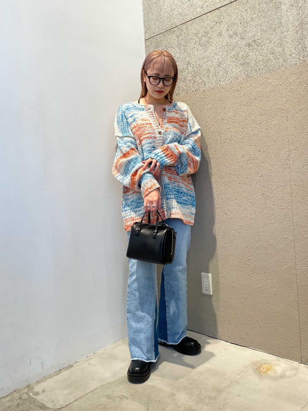 ホワイト系のカーディガン/ボレロ、ブラック系のバッグ、ブルー系のデニムパンツを着用したレディースの秋コーディネートの1枚目の写真