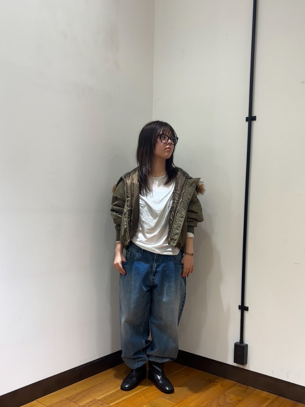 ホワイト系のTシャツ/カットソー、ブラウン系のダウンジャケット/コート、ブルー系のデニムパンツを着用したレディースの秋コーディネートの1枚目の写真