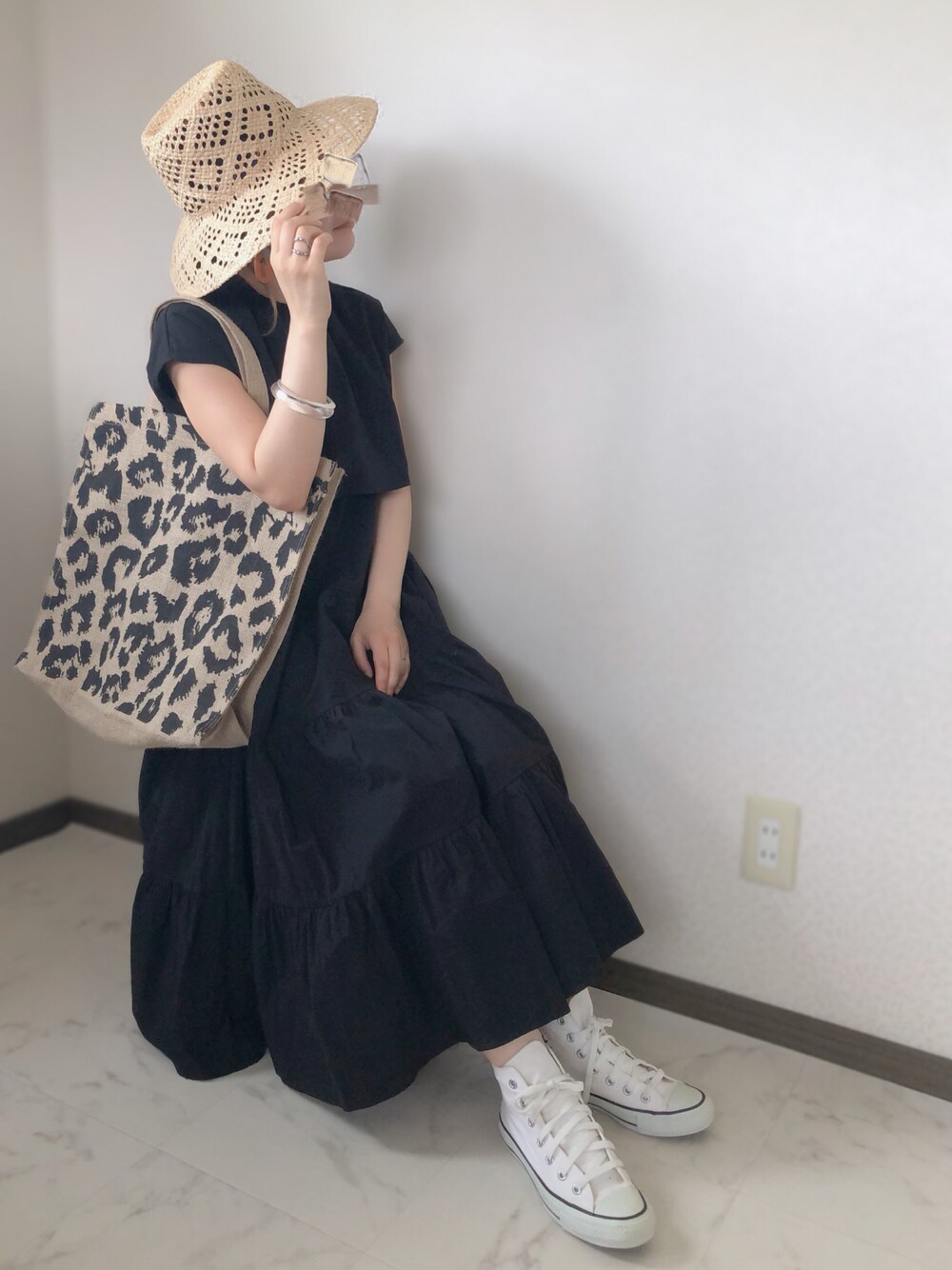 ブラック系のワンピース、ブラック系のトートバッグ、ホワイト系のスニーカーを着用したレディースの夏コーディネートの1枚目の写真
