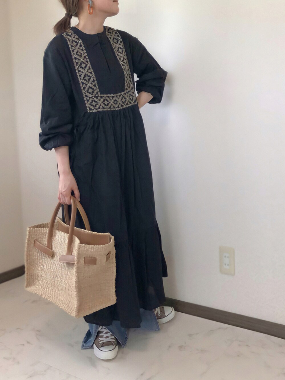 ブルー系のデニムパンツ、ブラウン系のスニーカー、ベージュ系のかごバッグを着用したレディースの夏コーディネートの1枚目の写真