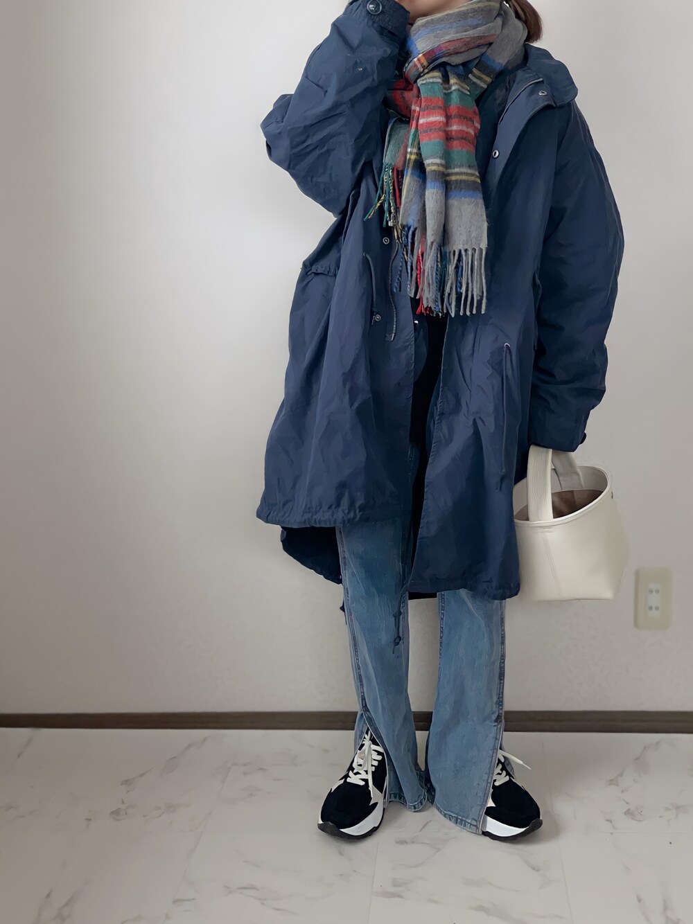 ブルー系のモッズコート、ブルー系のデニムパンツ、ブラック系のスニーカーを着用したレディースの冬コーディネートの1枚目の写真