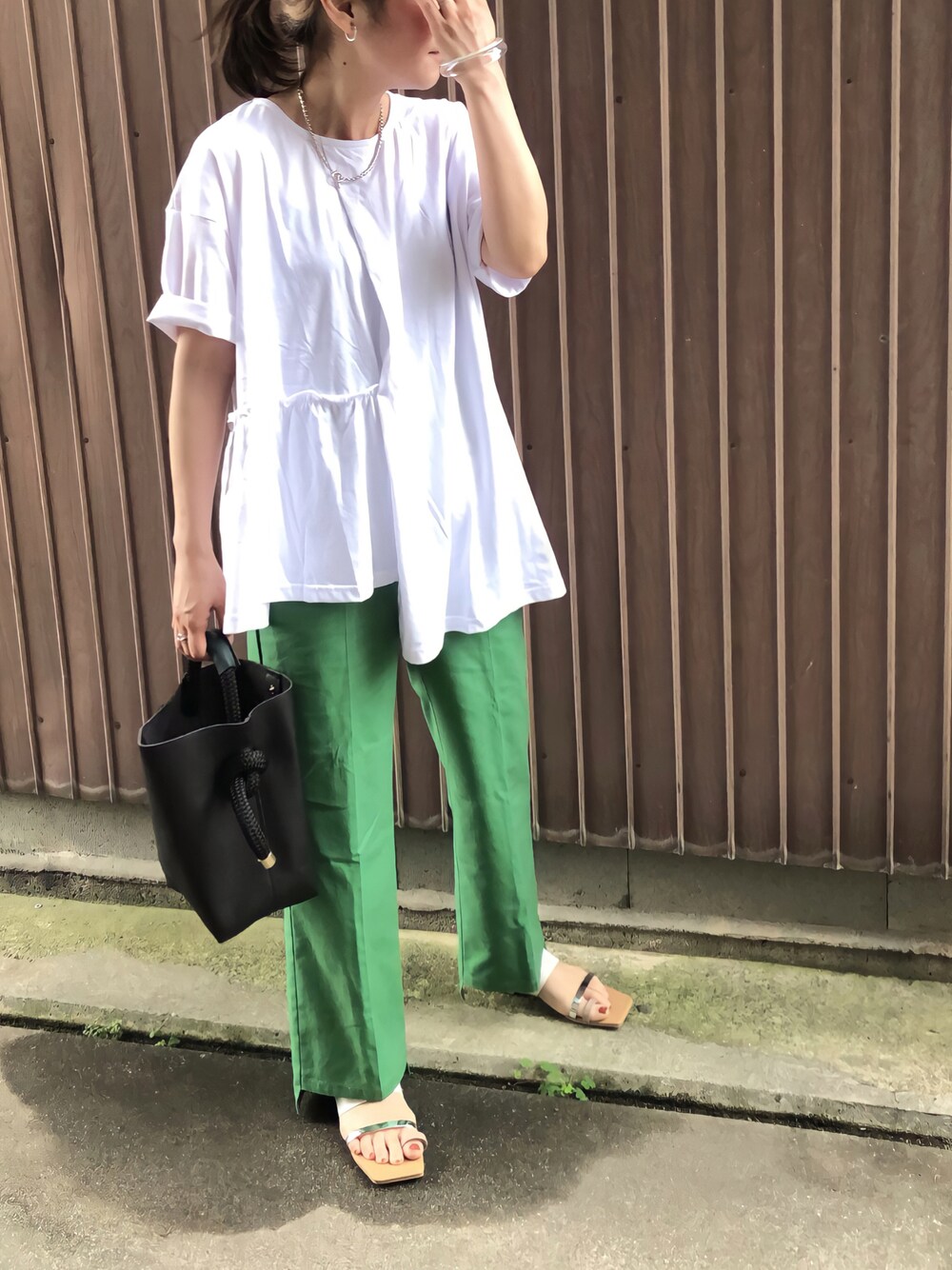 グリーン系のその他パンツ、ホワイト系のサンダル、ブラック系のハンドバッグを着用したレディースの夏コーディネートの1枚目の写真