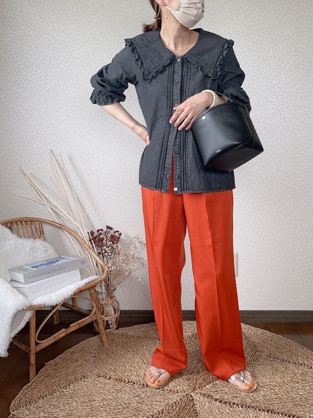 ブラック系のシャツ/ブラウス、オレンジ系のスラックス、ゴールド系のピアス（両耳用）を着用したレディースの夏コーディネートの1枚目の写真