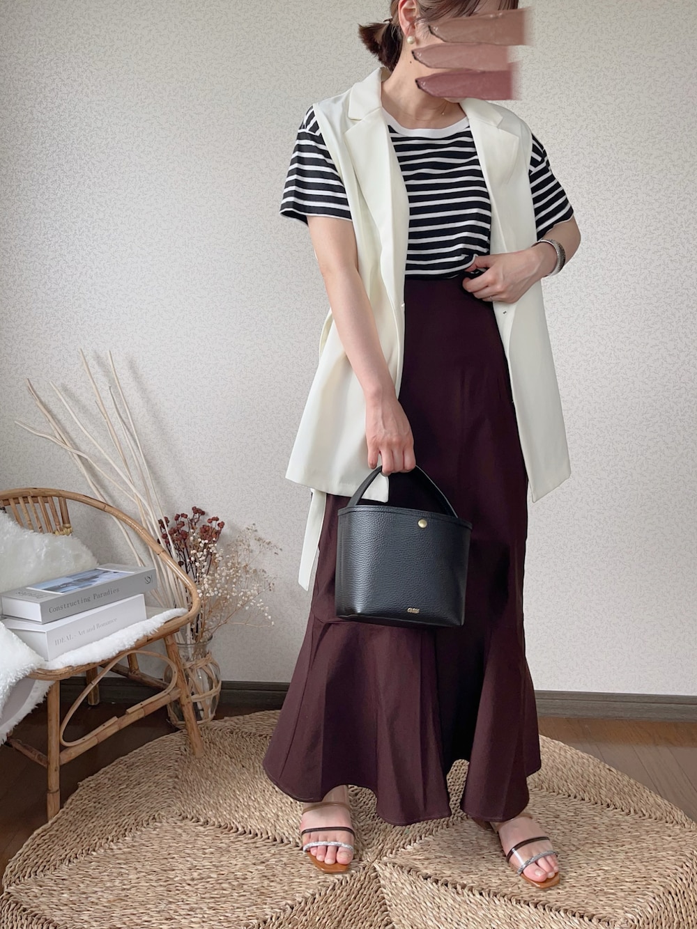 ブラウン系のスカート、ホワイト系のベストを着用したレディースの夏コーディネートの1枚目の写真