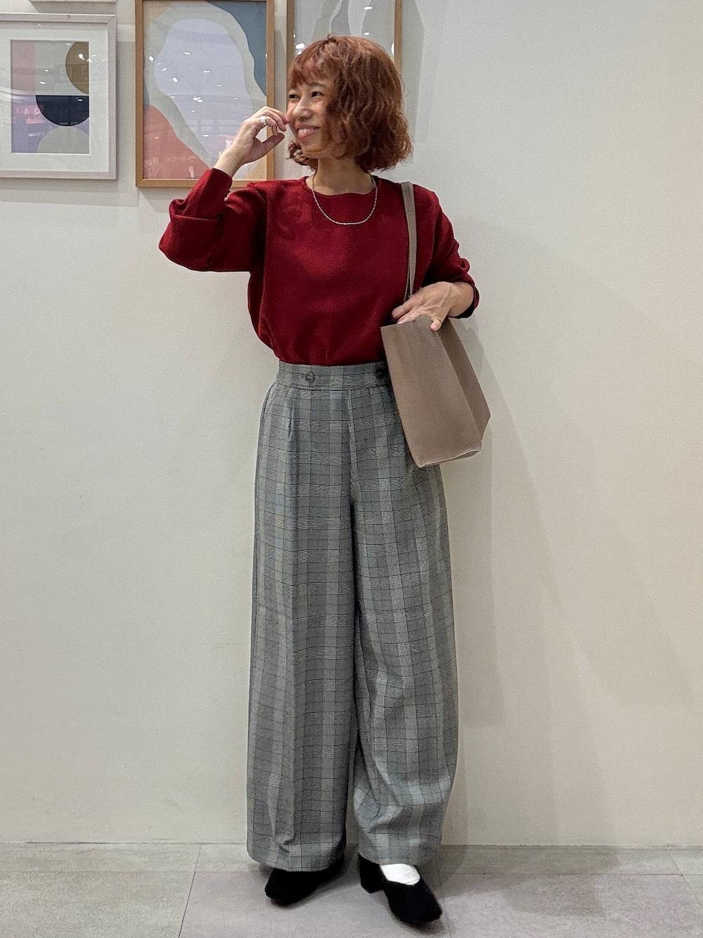 レッド系のニット/セーター、グレー系のその他パンツ、ブラック系のパンプスを着用したレディースの秋コーディネートの1枚目の写真