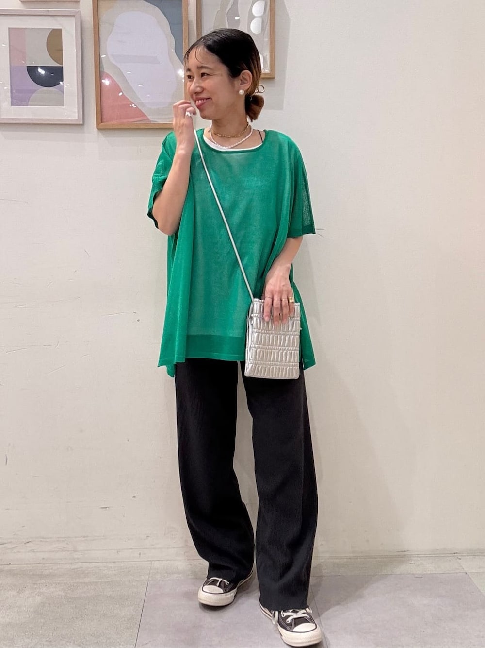 グリーン系のその他トップス、グレー系のその他パンツ、シルバー系のショルダーバッグを着用したレディースの春コーディネートの1枚目の写真