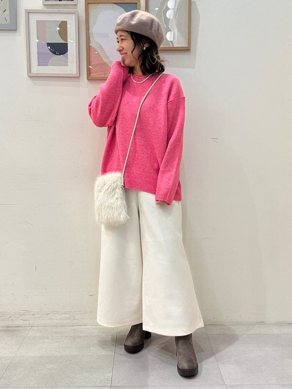 ピンク系のニット/セーター、ホワイト系のその他パンツ、ブラウン系のブーツを着用したレディースの冬コーディネートの1枚目の写真