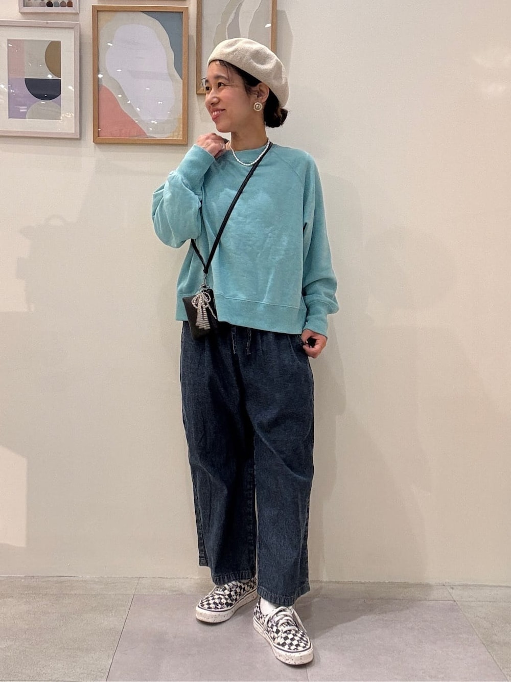 ブルー系のスウェット、ブルー系のデニムパンツ、ベージュ系のハンチング/ベレー帽を着用したレディースの春コーディネートの1枚目の写真