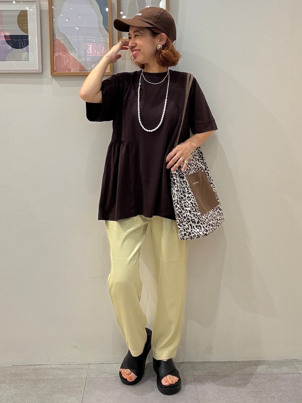 ブラウン系のTシャツ/カットソー、イエロー系のその他パンツ、ブラウン系のトートバッグを着用したレディースの夏コーディネートの1枚目の写真